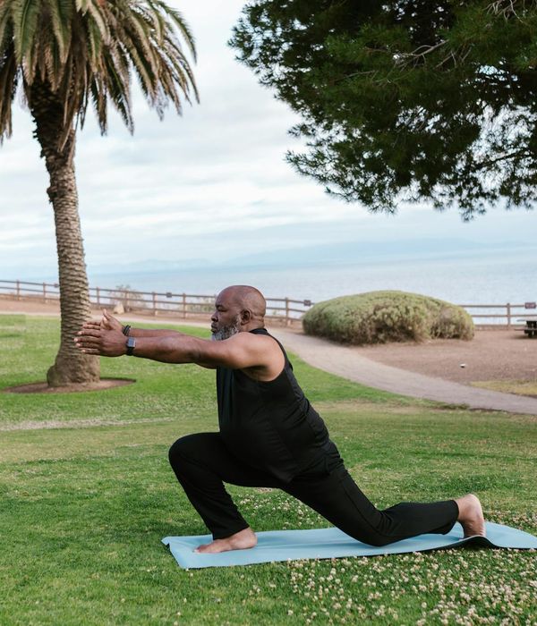 Male athlete in a focused yoga pose on a green mat.